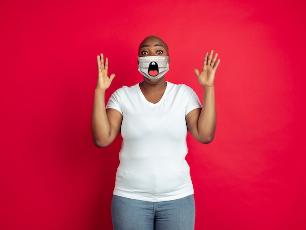 Asombrado, retrato, de, joven, mujer afroamericana, con, emoción, en, ella, protector, máscara facial