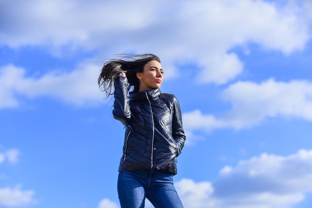 Aspecto de belleza y moda Siéntase libre de un día ventoso Mujer disfrutando del clima fresco Frescura de la mañana Explore su verdadero estilo Chica chaqueta de primavera fondo de cielo azul Modelo de moda de mujer al aire libre