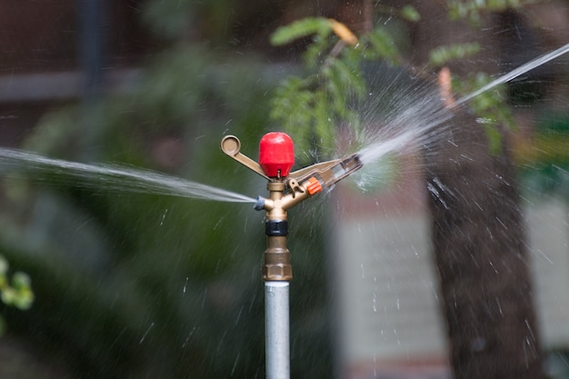 Foto aspersor automático de agua de metal.