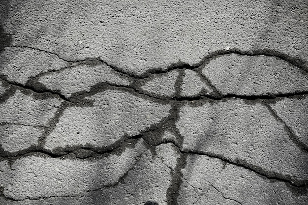 Asphalt in Rissen Textur / abstrakter Hintergrund Risse auf Asphaltstraße