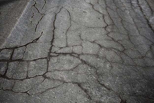 Asphalt in Rissen Textur / abstrakter Hintergrund Risse auf Asphaltstraße