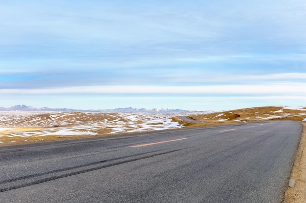 Asphaltstraße auf dem Hintergrund der tibetischen Hochebene