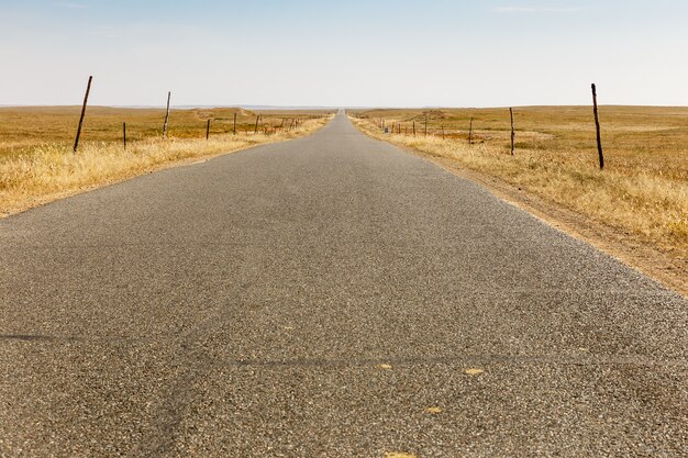 Asphaltstraße in der Steppe mit Windgeneratoren am Horizont, Innere Mongolei