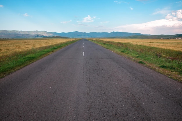 Asphaltstraße und Landschaft unter Himmel backgroundxA