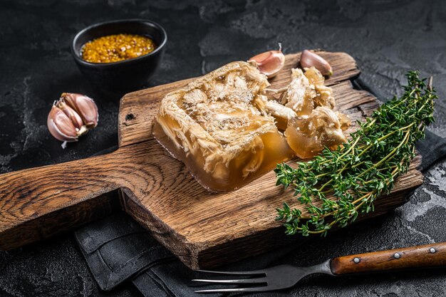 Aspic com carne de frango na placa de madeira. Fundo preto. Vista do topo.