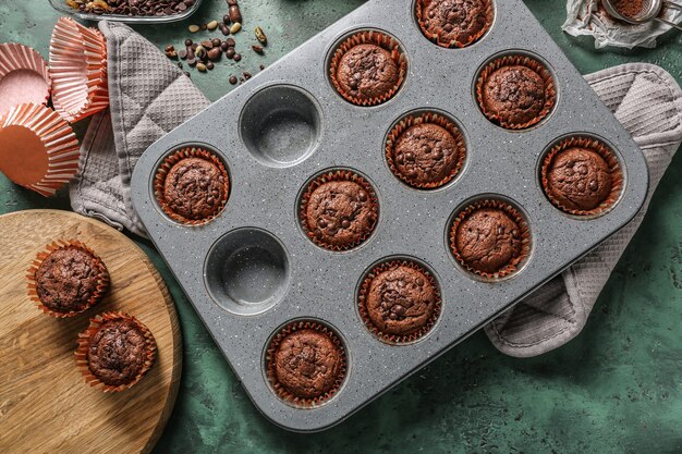 Assadeira com saborosos muffins de chocolate na mesa