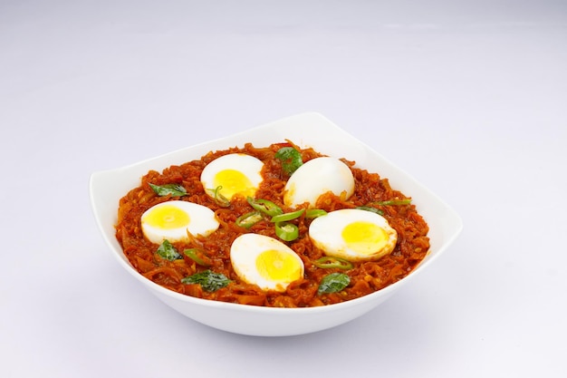 Assado de ovo ou ovo indiano masala curry assado de ovo vermelho picante disposto em uma tigela de cerâmica branca