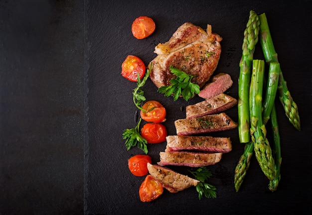 Assado grelhado carne de bife com aspargos e tomates.