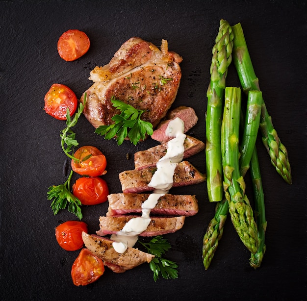 Assado grelhado carne de bife com aspargos e tomates.