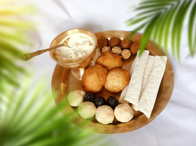 Assamische traditionelle Lebensmittel wie Pitha laddu doi sira mit assamischem Gamosa-Hintergrund