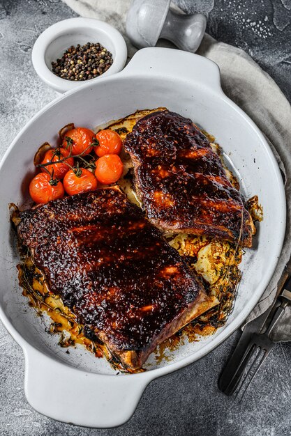 Asse as costeletas de porco em uma assadeira. Carne grelhada.