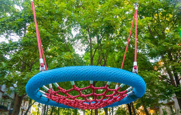 Foto assento de balanço redondo feito de malha no playground ninho de corda azul vazio para close-up balançando