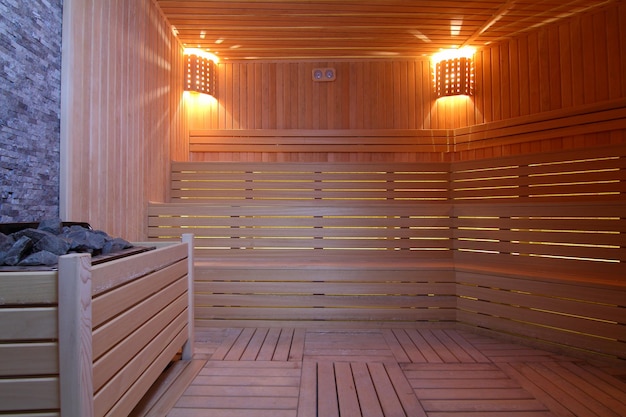 Assento na sala de sauna Sala de vapor de madeira vazia com aquecedor de pedraSauna para uma boa saúde