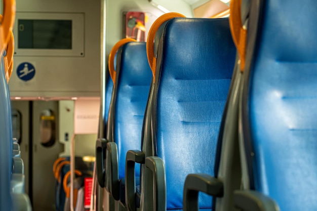 Assentos interiores do trem ferroviário em um trem em uma carruagem de trem com assentos azuis