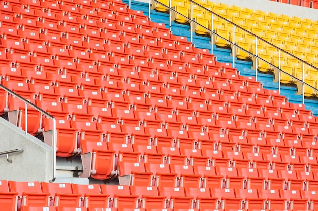 Foto assentos laranja e amarelos vazios no estádiofilas de assento em um estádio de futebol