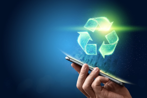 Assine o holograma de reciclagem sobre o tablet na mão. O conceito de terra limpa, eliminação de lixo.
