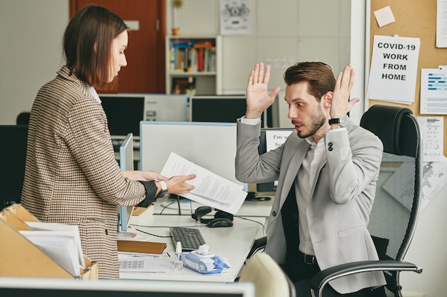 Foto assistent, der dem manager den vertrag zeigt und den vertrag erklärt