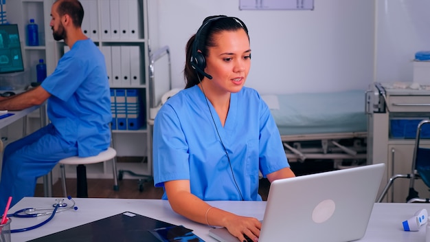 Assistent, der medizinische Online-Dienste mit Kopfhörern anbietet, Anrufe entgegennimmt und Termine vereinbart. Krankenhaus-Callcenter Arzt im Gesundheitswesen in der Medizinklinik, Arzthelferin an der Rezeption, die mit Co . hilft