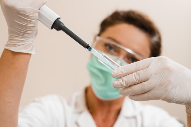 Assistente de laboratório com dispensador em laboratório fazendo análise de exames de sangue Equipamento médico em laboratório Cientista com dispensador de sangue fazendo análise hematológica de sangue