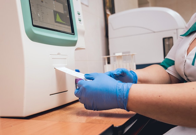 Assistente de laboratório realiza um exame de sangue.