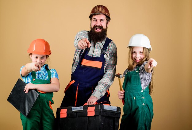 Assistente de trabalhador da construção civil Construtor ou carpinteiro Reparador de uniforme Foreman Família trabalho em equipe Reparar Pai e filha na oficina Homem barbudo com meninas Cada detalhe é importante