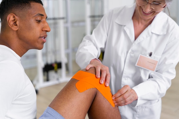 Foto assistente médico ajudando paciente com exercícios de fisioterapia