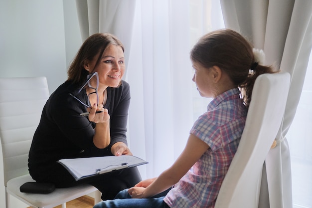 Assistente social de mulher falando com a garota. Psicologia infantil, saúde mental