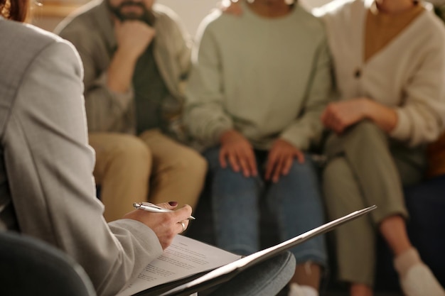 Assistente social fazendo anotações durante reunião com a família