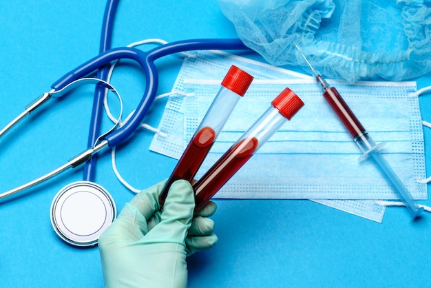 assistente técnico de laboratório ou médico segurando uma amostra de sangue em tubo de ensaio no laboratório