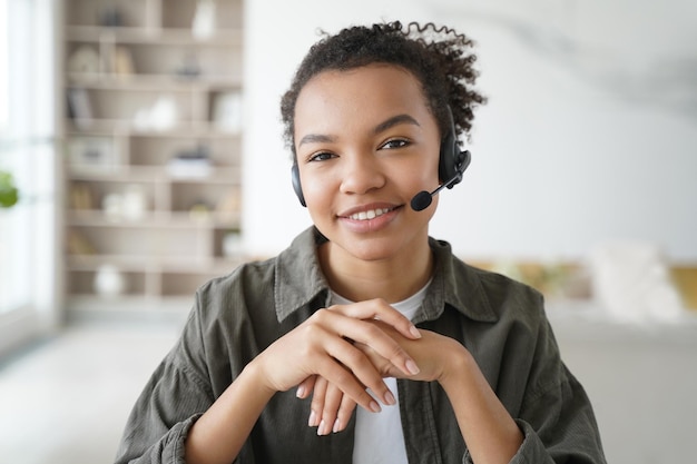 Assistente virtual Jovem afro no fone de ouvido é operadora do serviço de suporte ao cliente em casa