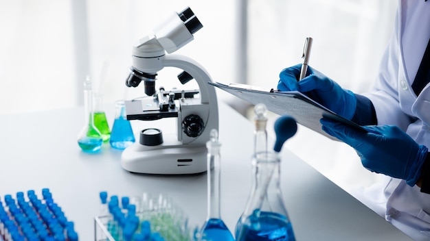 Assistentes de laboratório estão investigando reações químicas cientistas médicos pesquisadores químicos experimentos químicos e testes de doenças a partir de amostras de sangue de pacientes Medicina e conceito de pesquisa