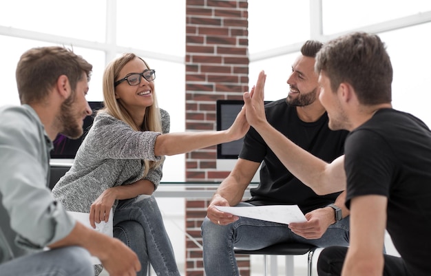 Associados de negócios de raça mista discutindo novo escritório moderno de plano de projeto