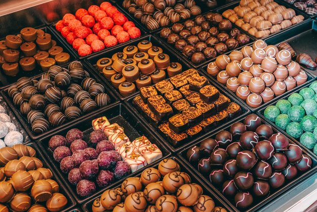 Assortimento de doces de chocolate fino, chocolate branco escuro e leite, doces de fundo