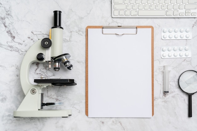 Assunto de biologia e química do microscópio na mesa da vista superior