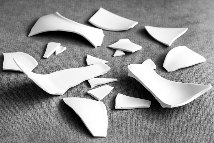 Astillas y fragmentos de la vajilla blanca rota Vidrio de placa rota Piezas de platos destrozados vista lateral de primer plano