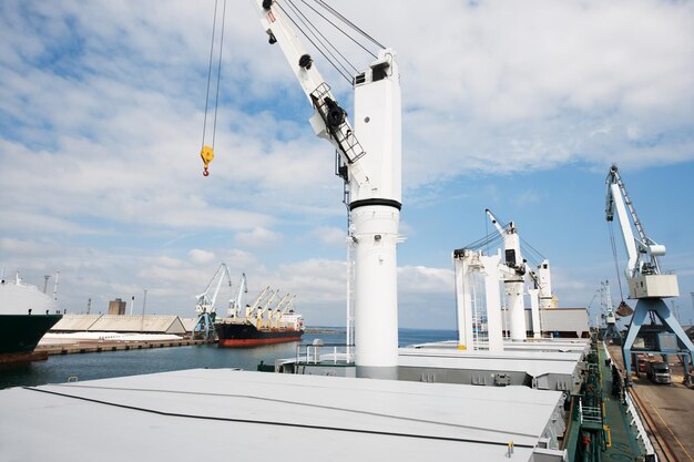 Foto el astillero nunca duerme. una foto de un puerto con barcos anclados con grúas.