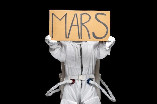 Astronaut Day Spaceman im Galaxie-Raumanzug, der den Planeten MARS hält, geschrieben auf dem Schrank, der das Gesicht bedeckt