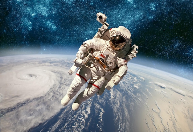 Astronaut im Weltraum vor dem Hintergrund des Planeten Erde. Taifun über dem Planeten Erde. Elemente dieses von der NASA bereitgestellten Bildes.