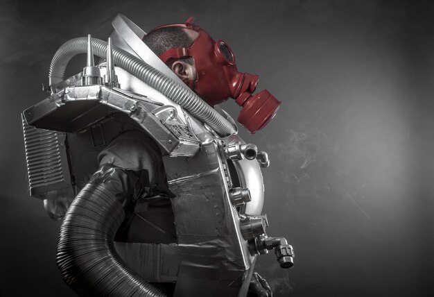 Astronaut mit roter Gasmaske auf schwarzem Hintergrund mit riesiger Waffe.