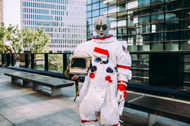 Astronauta alienígena en una estación futurista. astronauta con traje espacial caminando en un área urbana