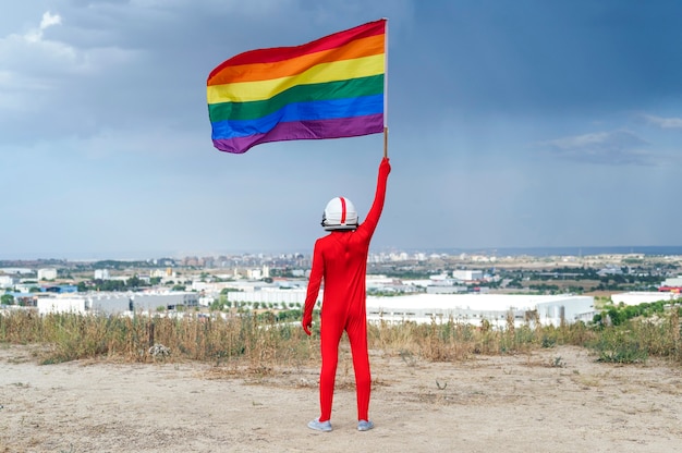 Astronauta con bandera LGBT. Vista desde atrás