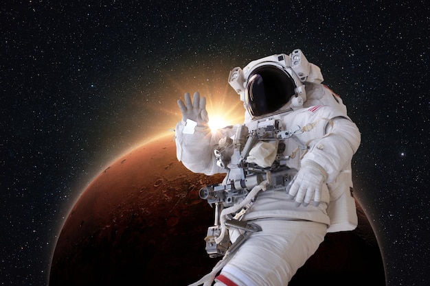 Astronauta bem sucedido em um traje espacial levita no espaço e explora o incrível planeta vermelho Marte com os raios do nascer do sol Spaceman viaja no espaço profundo e realiza uma missão espacial