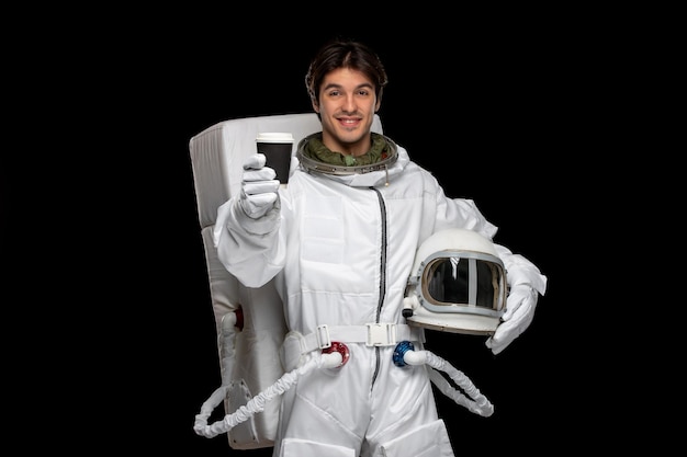 Astronauta do dia do astronauta no espaço sideral cosmos galáxia capacete fora segurando a xícara de café preta para tirar