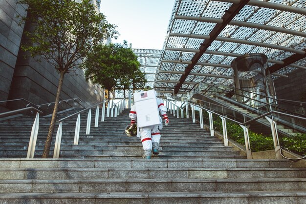 Astronauta en una estación futurista. Hombre con traje espacial caminando en una zona urbana