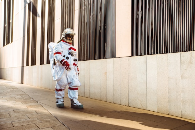 Astronauta en una estación futurista. Hombre con traje espacial caminando en una zona urbana