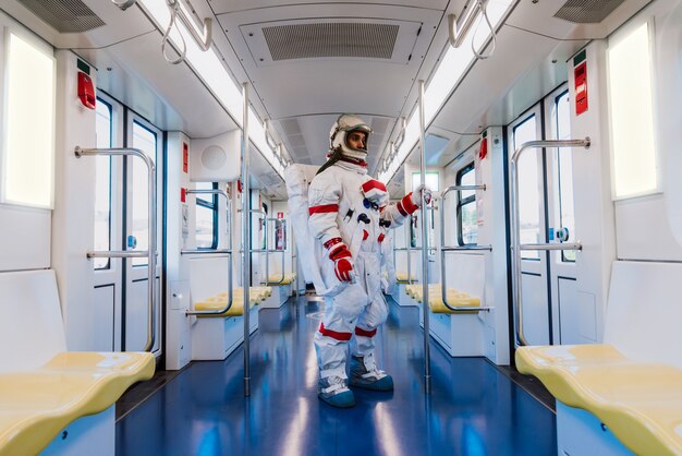 Astronauta en una estación futurista. Hombre con traje espacial saliendo a trabajar y cogiendo el tren