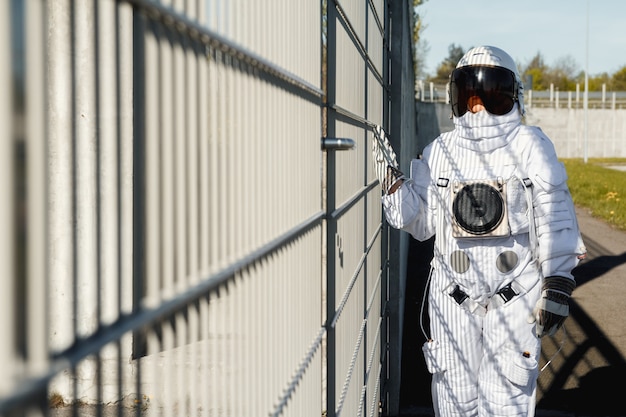 Foto astronauta en el fondo de la ciudad futurista, vislumbrar el futuro. fantástico disfraz cósmico.