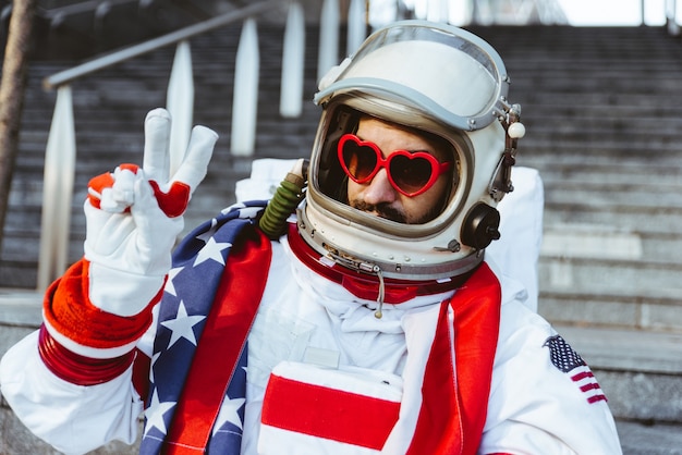 Foto astronauta lgbt en una estación futurista hombre con traje espacial caminando en una zona urbana