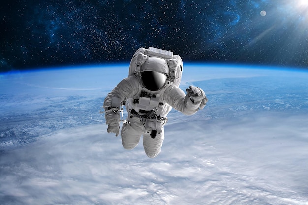 Astronauta no espaço aberto sobre o planeta Terra. As estrelas fornecem o plano de fundo. Executando um espaço acima do planeta Terra. Nascer do sol, pôr do sol. Nossa casa. ISS.Elements of this Image fornecido pela NASA.
