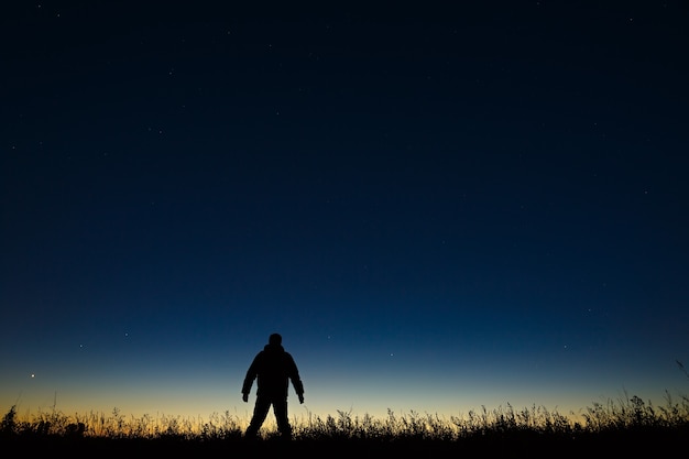 El astrónomo y el cielo estrellado de la noche en la superficie de un horizonte crepuscular